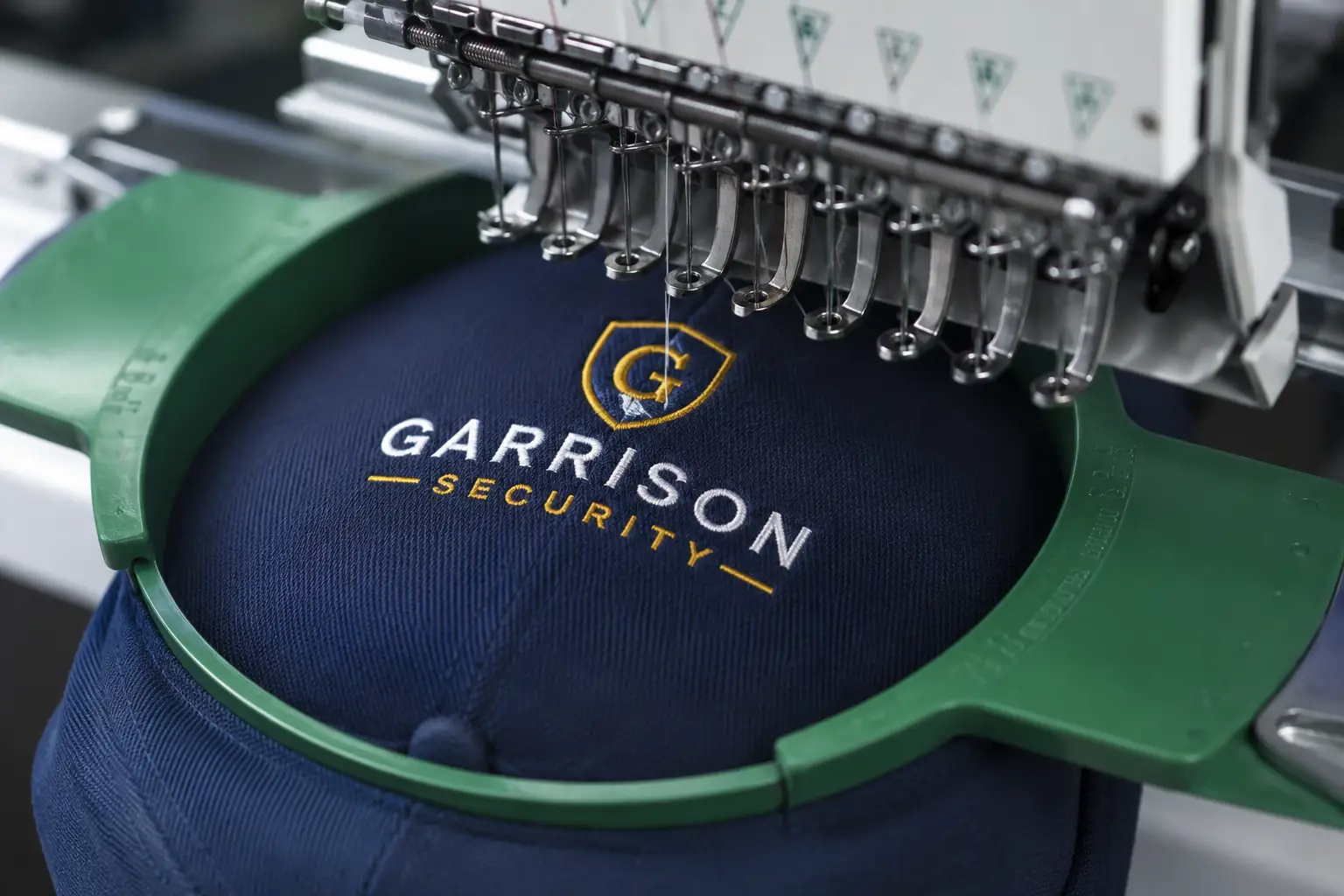 Embroidered cap on the hoop, machine mid-stitch Embroidered cap on the hoop, machine mid-stitch